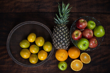fruits arranged on a rustic wooden surface with a black background. top view.