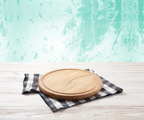 Empty pizza board and tablecloth on wooden deck table with napkin