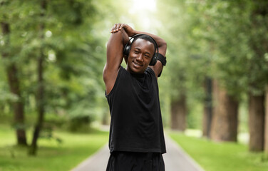 Smiling black sportsman enjoying exercising at park