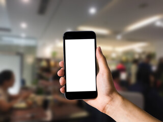 Mockup image of hand holding white mobile phone with blank white screen in cafe.