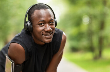 Fototapeta premium Closeup of cheerful black jogger with wireless headset