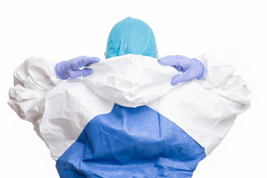 Female doctor with PPE putting on cap on white background