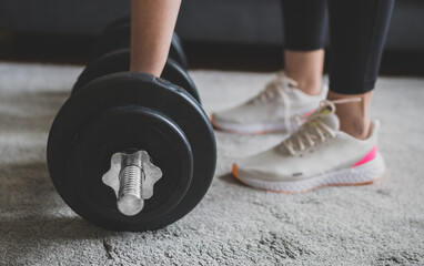 Woman is preparing to work out with dumbbells. Home fitness training concept.