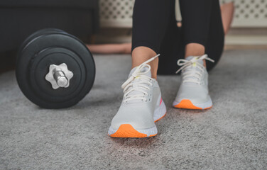 Woman resting between exercise sets. Home fitness training concept.