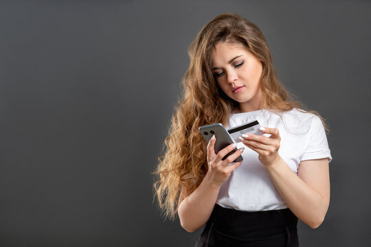 Cashless payment. Online shopping. Woman using credit card mobile app on phone isolated on gray copy space.