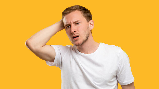 Troubled man portrait. Mistake regret. Concerned guy touching head isolated on orange background.