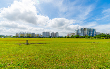 An array of multi-storey buildings in the middle of the field sky background in singapore city. decoration image contain certain grain noise and soft focus.
