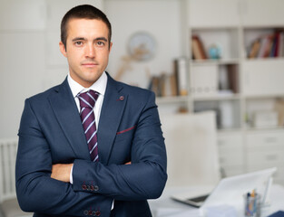 Portrait of smiling businessman who is at his work place in office