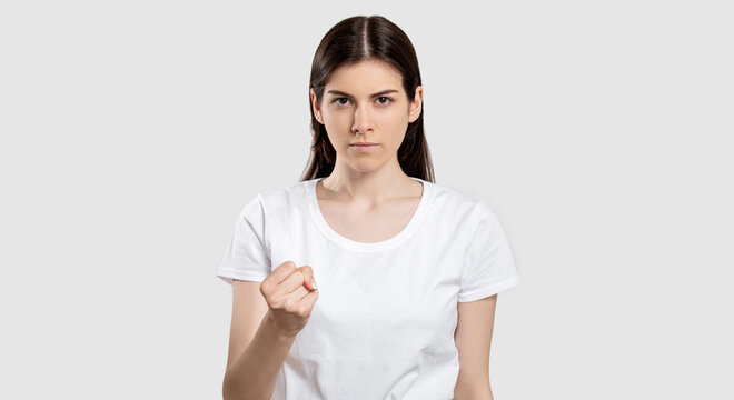Angry woman portrait. Strike riot. Confident female activist warning with fist isolated on neutral background.