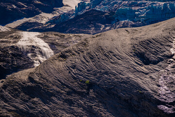 Fototapeta na wymiar Melting glacier before blank rock with small river and snow. Schmelzender Gletscher Global Warming Rosenlaui Schweiz 