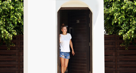 Beautiful woman opening the door of her home.