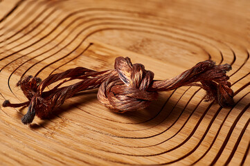 A piece of copper wire lies on a wooden table