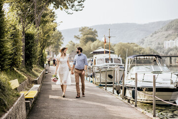 Stylish couple walking quay with nature background