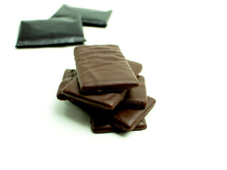 Slices of cold and dark chocolate on an isolated white background
