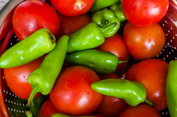 Fresh green chillies and tomatoes in a bowl
