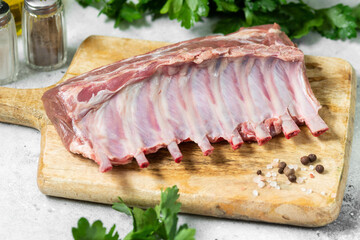 Lamb meat. Lamb ribs on a wooden chopping Board on the light gray kitchen table. Raw lamb meat on the table, loin