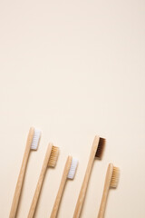 Bamboo toothbrushes arranged on cream background