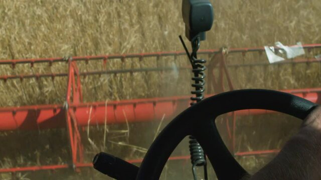 Farmer driving a harvester hands on stearing wheel
