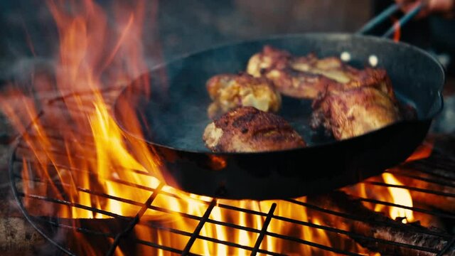 Cooking chicken over a campfire
