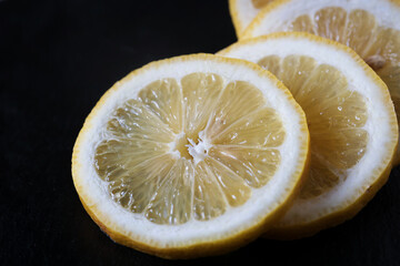 round slices of lemon on a black background