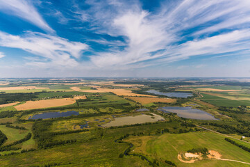 View from a sports helicopter to the fields of Belarus. Field, meadow, ponds, rivers, lakes. Summer day. Helicopter views of the territory. Belorussia villages