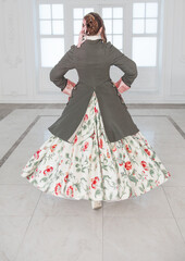 Beautiful woman in medieval dress and frock-coat. Back pose