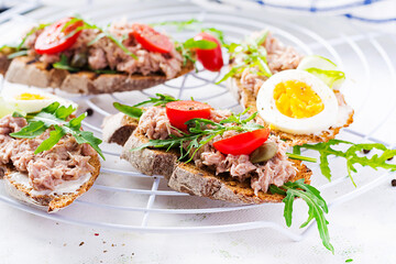 Toasts with tuna. Italian bruschetta sandwiches with canned tuna, tomatoes and capers. Copy space