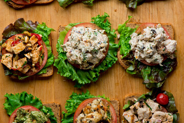 Obraz na płótnie Canvas Sandwiches. Tuna Salad. Chicken Salad. Served on slices of white, rye, and whole grain bread with lettuce and tomato. Traditional American lunch or snack favorite. 