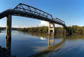 Fototapeta na wymiar beautiful early morning view of river with reflections of clear blue sky, bridge and trees on water, Parramatta river, Rydalmere, New South Wales, Australia