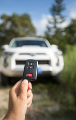 Driver hand holding a wireless remote control key to a off road car