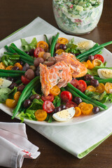 Nicoise salad. Romaine, cherry tomatoes hard boiled eggs, baby purple potatoes. green beans and grilled salmon tossed with olive oil and salt and pepper