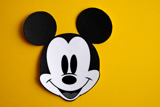 RUSSIA, ST.PETERSBURG - NOVEMBER 19, 2018: Black and white face of Mickey Mouse out of paper on a yellow background.