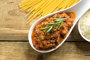 meat Bolognese sauce on a wooden table.