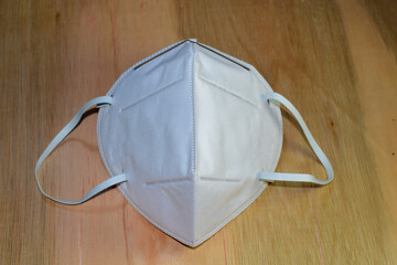 White dust mask isolated from ancient wooden background