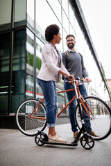 Obraz premium Happy couple using electric scooter, bicycle in city. Green eco energy concept with zero emission