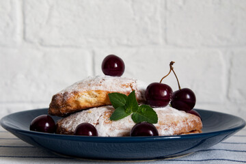 Cakes with cherry on a plate. Сottage cheese patty.