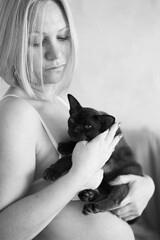 Beautiful woman and burmese kitten. A woman holds a kitten in her arms. Burmese cat at home. Bright interior in the kitchen.