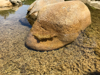 Fototapeta na wymiar Clear water and a large stone