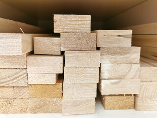 Stack of natural brown uneven rough wooden boards on building site. Industrial timber for carpentry, building, repairing and furniture, lumber material for roofing construction.