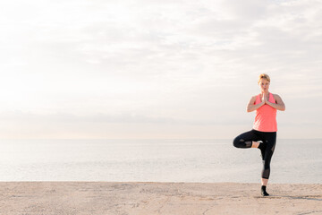 woman practicing yoga balance at sunrise