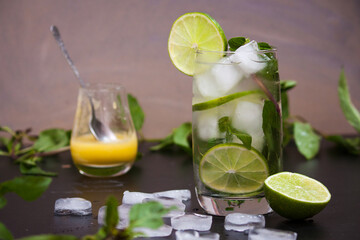 Summer coctail mojito with ice, mint, lime on a grey background. Copy space.