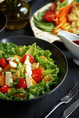 Various culinary dishes on a dark wooden table. Exquisite restaurant serve on dark dishes