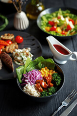 Various culinary dishes on a dark wooden table. Exquisite restaurant serve on dark dishes