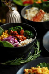 Various culinary dishes on a dark wooden table. Exquisite restaurant serve on dark dishes