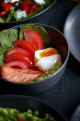 Various culinary dishes on a dark wooden table. Exquisite restaurant serve on dark dishes