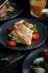 Various culinary dishes on a dark wooden table. Exquisite restaurant serve on dark dishes