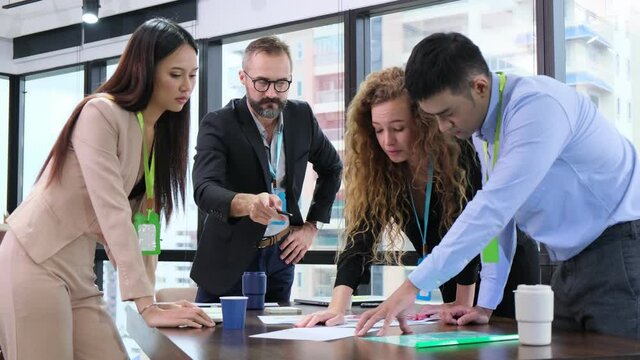 Group of businesspeople discuss on project and caucasian businessmen point to the graph. Teamwork of businesses of different ethnicity. Feeling happy fun and smile. Planing and successful concept
