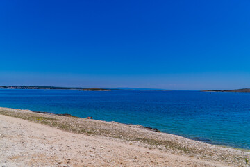 Fototapeta na wymiar Wild stone beach on the coast of Kamenjak National Park in Premantura, Istria, Croatia