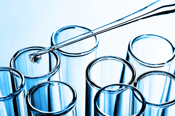 Laboratory test tube background. Covid-19 corona virus pandemic crisis. Glass pipette fluid drop....