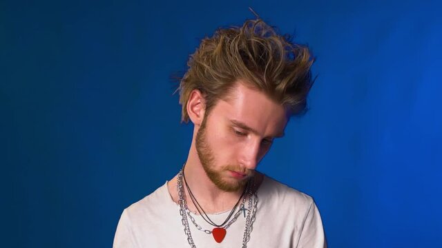 Young hipster guy with beard and chains posing for the camera